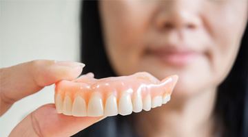 Woman holding her denture