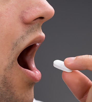 Man taking oral sedative pill