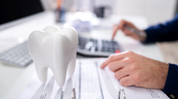 patient calculating cost of dental crown 